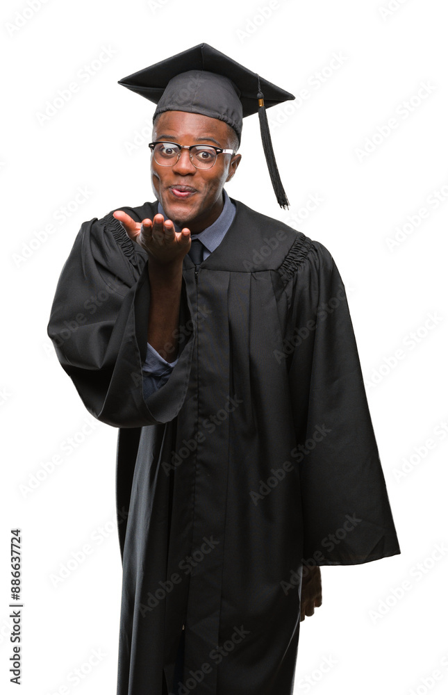 Young graduated african american man over isolated background looking at the camera blowing a kiss with hand on air being lovely and sexy. Love expression. Young graduated african american man over isolated background looking at the camera blowing a kiss with hand on air being lovely and sexy. Love expression.
