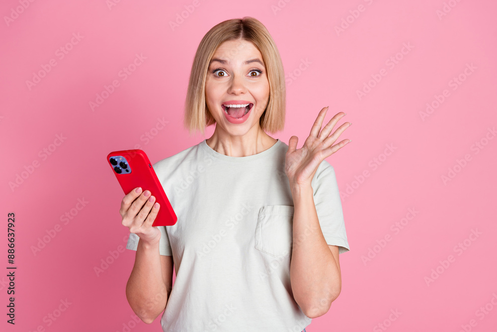 Photo of overjoyed nice woman with bob hairdo dressed t-shirt holding smartphone staring open mouth isolated on pink color background Photo of overjoyed nice woman with bob hairdo dressed t-shirt holding smartphone staring open mouth isolated on pink color background