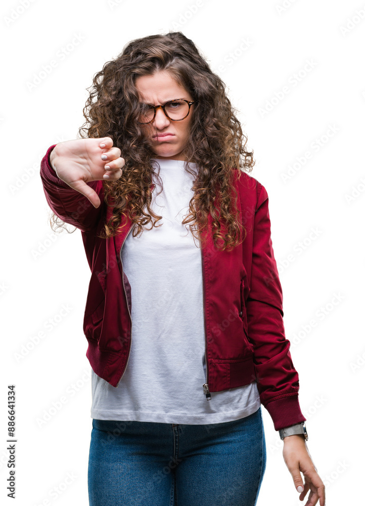 Beautiful brunette curly hair young girl wearing jacket and glasses over isolated background looking unhappy and angry showing rejection and negative with thumbs down gesture. Bad expression. Beautiful brunette curly hair young girl wearing jacket and glasses over isolated background looking unhappy and angry showing rejection and negative with thumbs down gesture. Bad expression.