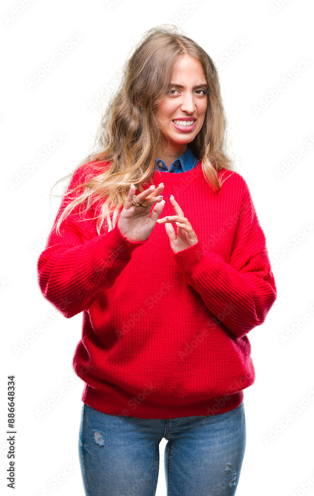 Beautiful young blonde woman wearing winter sweater over isolated background disgusted expression, displeased and fearful doing disgust face because aversion reaction. With hands raised. Beautiful young blonde woman wearing winter sweater over isolated background disgusted expression, displeased and fearful doing disgust face because aversion reaction. With hands raised.