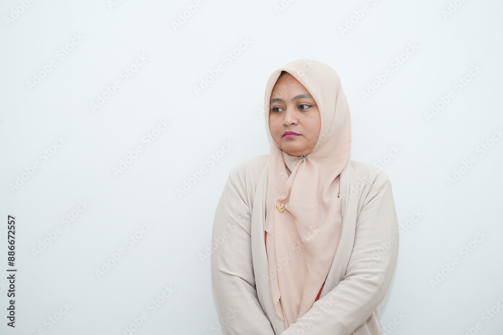 Fototapeta premium Portrait of a beautiful young Asian Muslim woman wearing a hijab being photographed in a studio