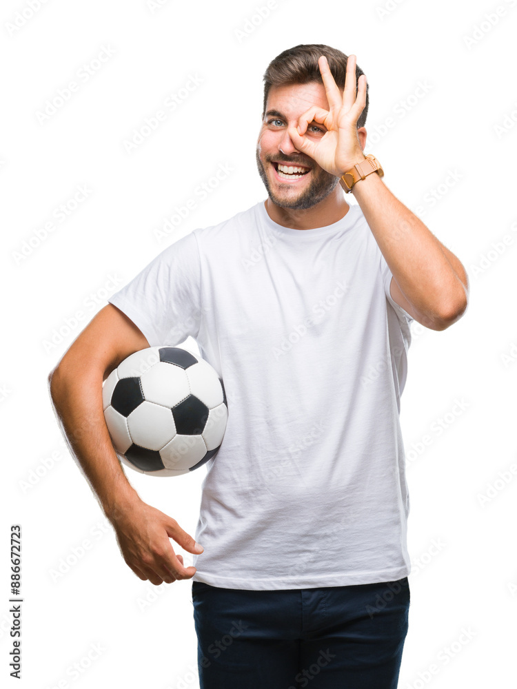 Young handsome man holding soccer football ball over isolated background with happy face smiling doing ok sign with hand on eye looking through fingers Young handsome man holding soccer football ball over isolated background with happy face smiling doing ok sign with hand on eye looking through fingers