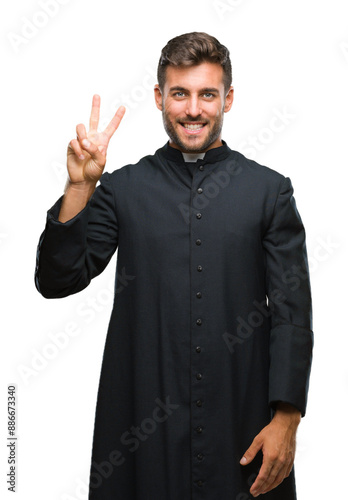 Young catholic christian priest man over isolated background showing and pointing up with fingers number two while smiling confident and happy. photo