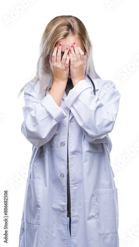 Young blonde doctor woman over isolated background with sad expression covering face with hands while crying. Depression concept.