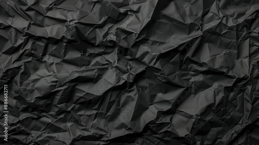 Crumpled black paper texture with folds on a dark background for wallpaper Crumpled black paper texture with folds on a dark background for wallpaper