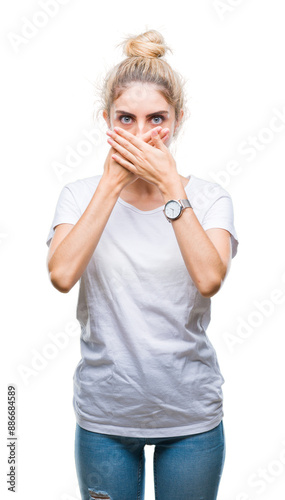 Young beautiful blonde woman wearing white t-shirt over isolated background shocked covering mouth with hands for mistake. Secret concept.