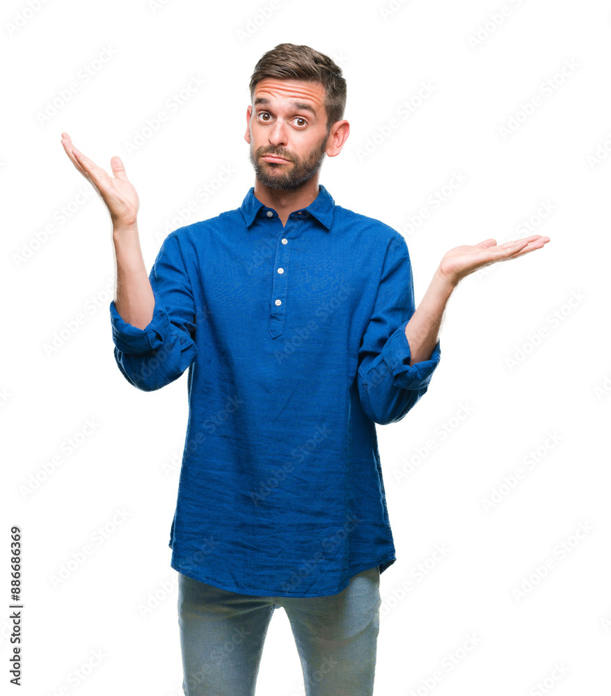Young handsome man over isolated background clueless and confused expression with arms and hands raised. Doubt concept.