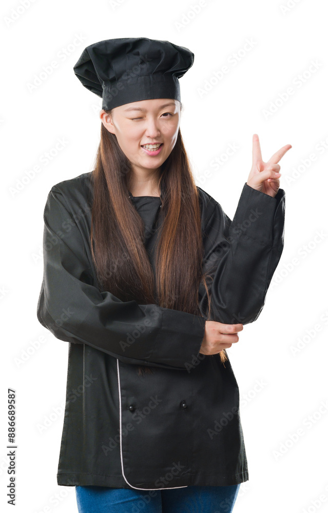 Young Chinese woman over isolated background wearing chef uniform smiling with happy face winking at the camera doing victory sign. Number two. Young Chinese woman over isolated background wearing chef uniform smiling with happy face winking at the camera doing victory sign. Number two.