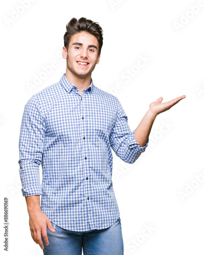 Young handsome business man over isolated background smiling cheerful presenting and pointing with palm of hand looking at the camera.