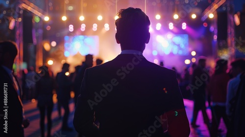 Man in Suit at a Vibrant Evening Event with Colorful Lights