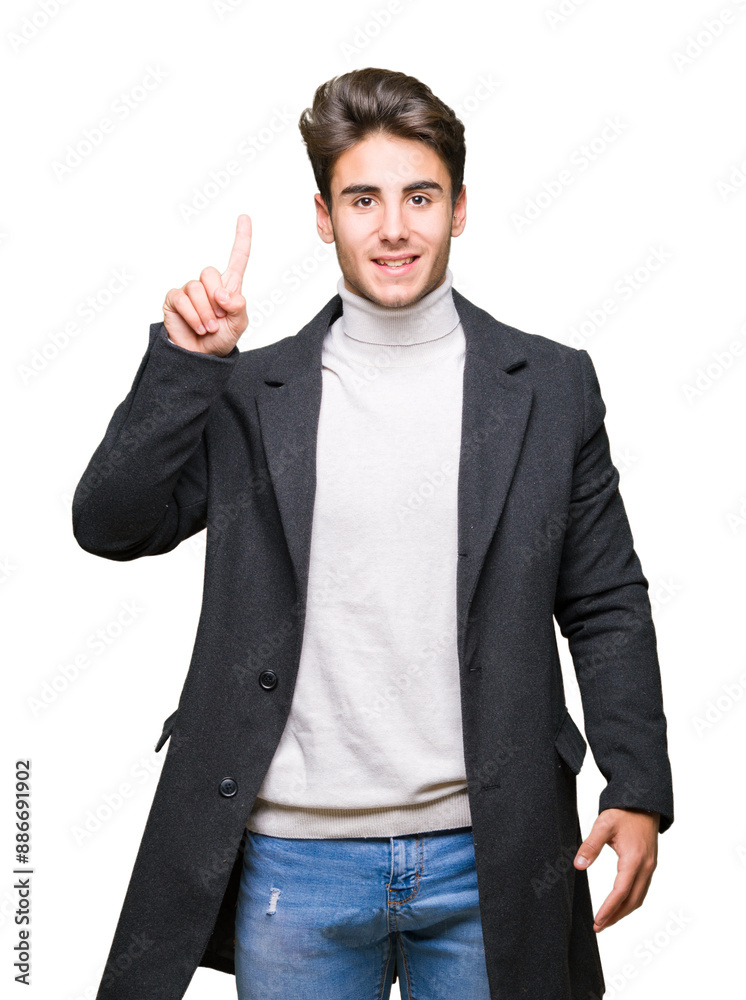 Young elegant man wearing winter coat over isolated background showing and pointing up with finger number one while smiling confident and happy. Young elegant man wearing winter coat over isolated background showing and pointing up with finger number one while smiling confident and happy.