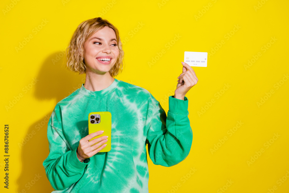 Photo of shiny attractive lady dressed tie dye sweatshirt enjoy online banking modern gadget empty space isolated yellow color background Photo of shiny attractive lady dressed tie dye sweatshirt enjoy online banking modern gadget empty space isolated yellow color background