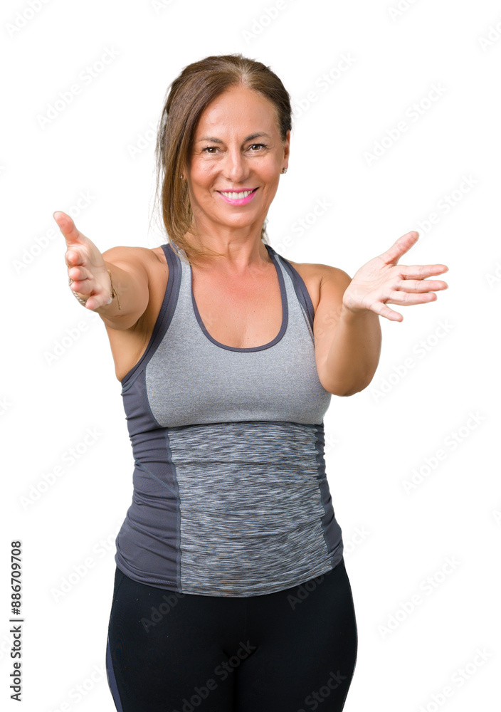 Beautiful middle age woman wearing sport clothes over isolated background looking at the camera smiling with open arms for hug. Cheerful expression embracing happiness. Beautiful middle age woman wearing sport clothes over isolated background looking at the camera smiling with open arms for hug. Cheerful expression embracing happiness.