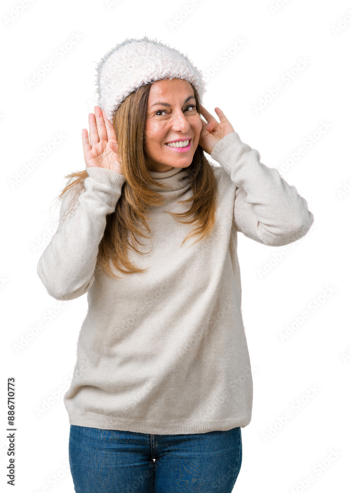 Beautiful middle age woman wearing winter sweater and hat over isolated background Trying to hear both hands on ear gesture, curious for gossip. Hearing problem, deaf Beautiful middle age woman wearing winter sweater and hat over isolated background Trying to hear both hands on ear gesture, curious for gossip. Hearing problem, deaf