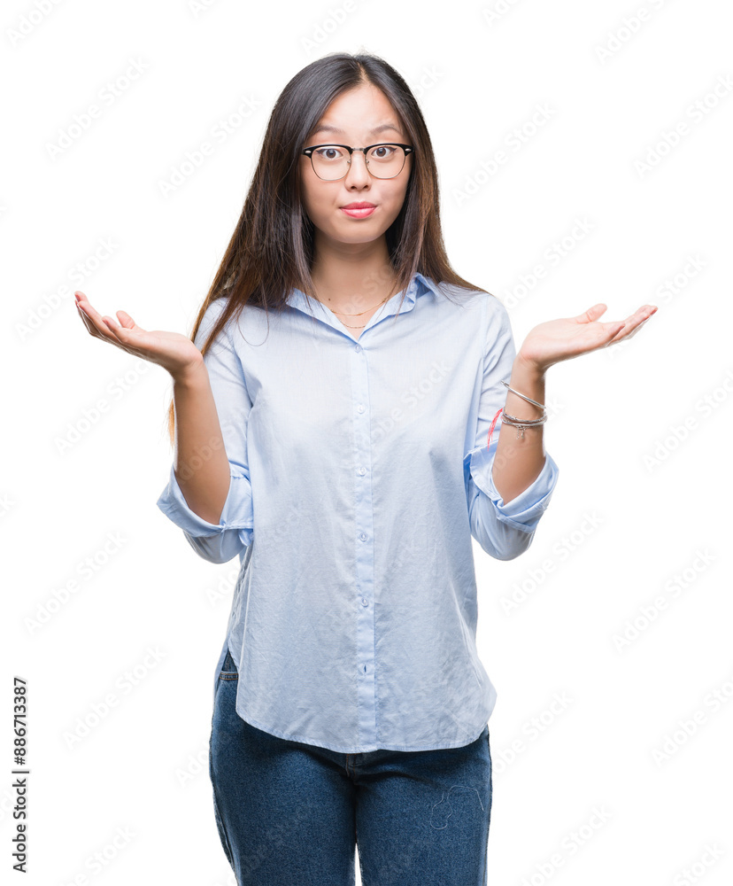Young asian business woman wearing glasses over isolated background clueless and confused expression with arms and hands raised. Doubt concept. Young asian business woman wearing glasses over isolated background clueless and confused expression with arms and hands raised. Doubt concept.