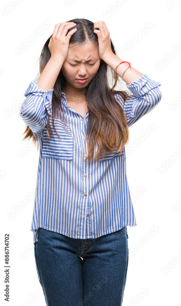 Young asian woman over isolated background suffering from headache desperate and stressed because pain and migraine. Hands on head. Young asian woman over isolated background suffering from headache desperate and stressed because pain and migraine. Hands on head.