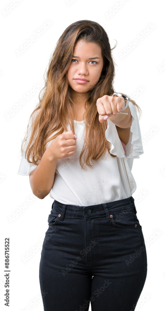 Young beautiful brunette business woman over isolated background Punching fist to fight, aggressive and angry attack, threat and violence Young beautiful brunette business woman over isolated background Punching fist to fight, aggressive and angry attack, threat and violence