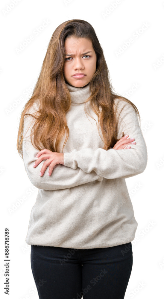 Young beautiful brunette woman wearing turtleneck sweater over isolated background skeptic and nervous, disapproving expression on face with crossed arms. Negative person.