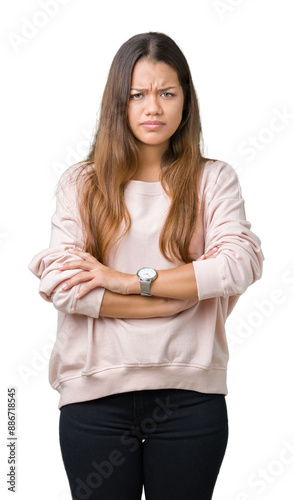 Young beautiful brunette woman wearing pink sweatshirt over isolated background skeptic and nervous, disapproving expression on face with crossed arms. Negative person.