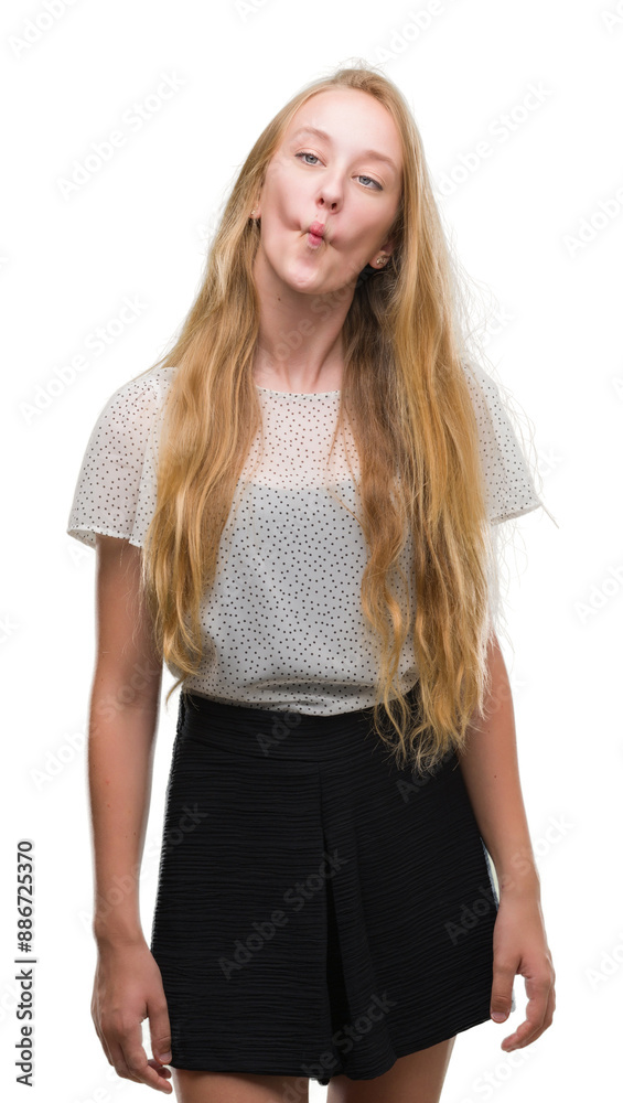 Blonde teenager woman wearing moles shirt making fish face with lips, crazy and comical gesture. Funny expression. Blonde teenager woman wearing moles shirt making fish face with lips, crazy and comical gesture. Funny expression.