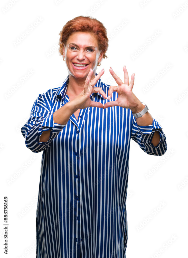 Obraz premium Atrractive senior caucasian redhead woman over isolated background smiling in love showing heart symbol and shape with hands. Romantic concept.