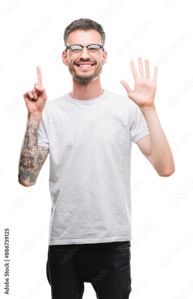 Young tattooed adult man showing and pointing up with fingers number six while smiling confident and happy. Young tattooed adult man showing and pointing up with fingers number six while smiling confident and happy.