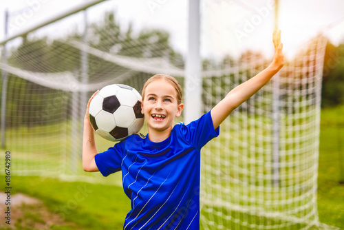 Kid play football on outdoor field at the end of the day