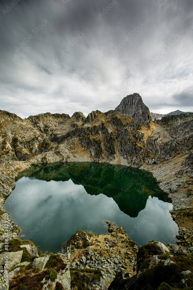 Obraz premium Photo de sommets des Pyrénées ariégeoises qui se reflètent dans un lac rond