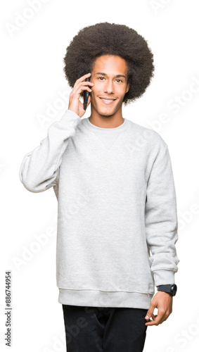 Young african american man with afro hair talking on smartphone with a happy face standing and smiling with a confident smile showing teeth