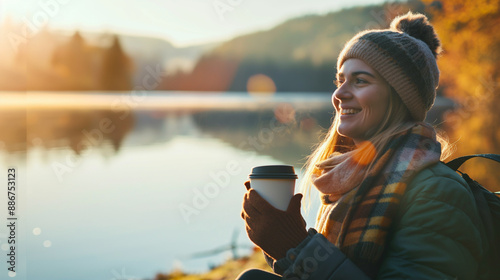 Mulher, lago e sorriso com café pela manhã, feliz e relaxado para férias na natureza. Nascer do sol, acampamento e bebida para cafeína no rio para férias na Alemanha, pessoa do sexo feminino e sol  photo