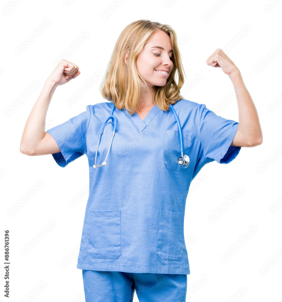 Fototapeta premium Beautiful young doctor woman wearing medical uniform over isolated background showing arms muscles smiling proud. Fitness concept.