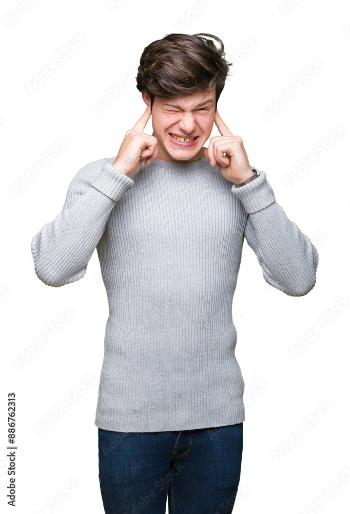 Young handsome man wearing winter sweater over isolated background covering ears with fingers with annoyed expression for the noise of loud music. Deaf concept. Young handsome man wearing winter sweater over isolated background covering ears with fingers with annoyed expression for the noise of loud music. Deaf concept.