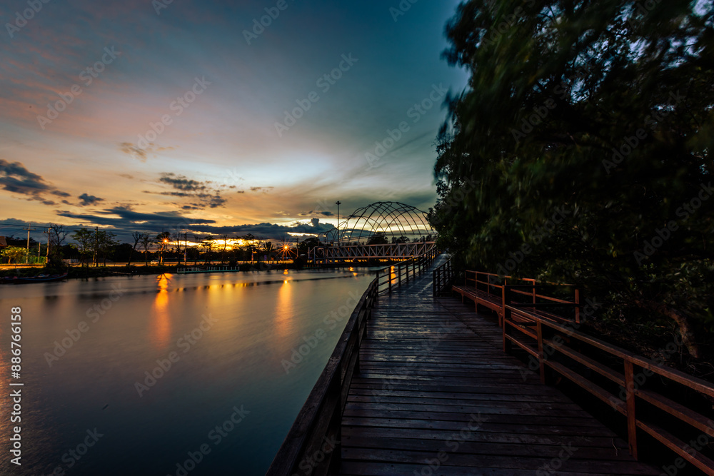 Fototapeta premium Close-up view of the natural background of the wooden bridge, which is surrounded by mangrove forests, colorful leaves of the leaves, blown through the blurred coolness during ecological travel.