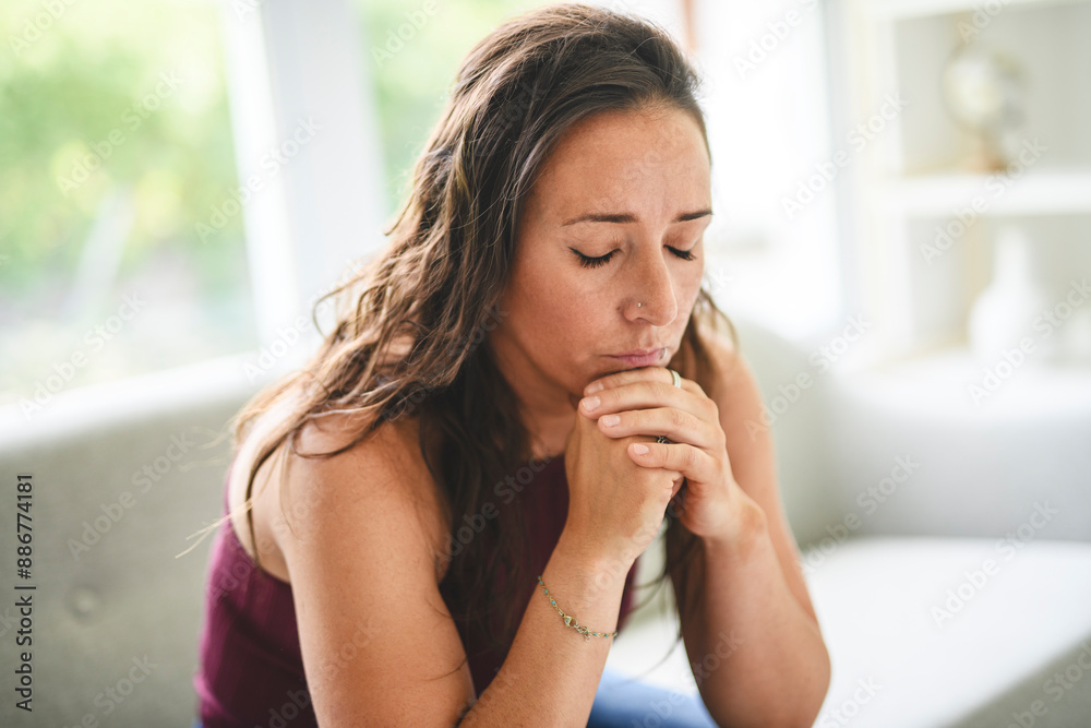 Sad woman in casual sitting on couch at home Sad woman in casual sitting on couch at home