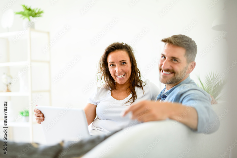bearded husband cuddling affectionate wife on computer at home. Using laptop in living room. bearded husband cuddling affectionate wife on computer at home. Using laptop in living room.