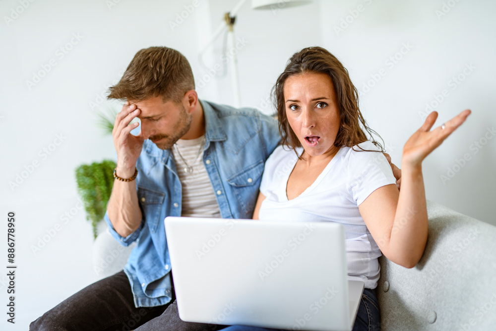 A couple on the living room look upset together A couple on the living room look upset together