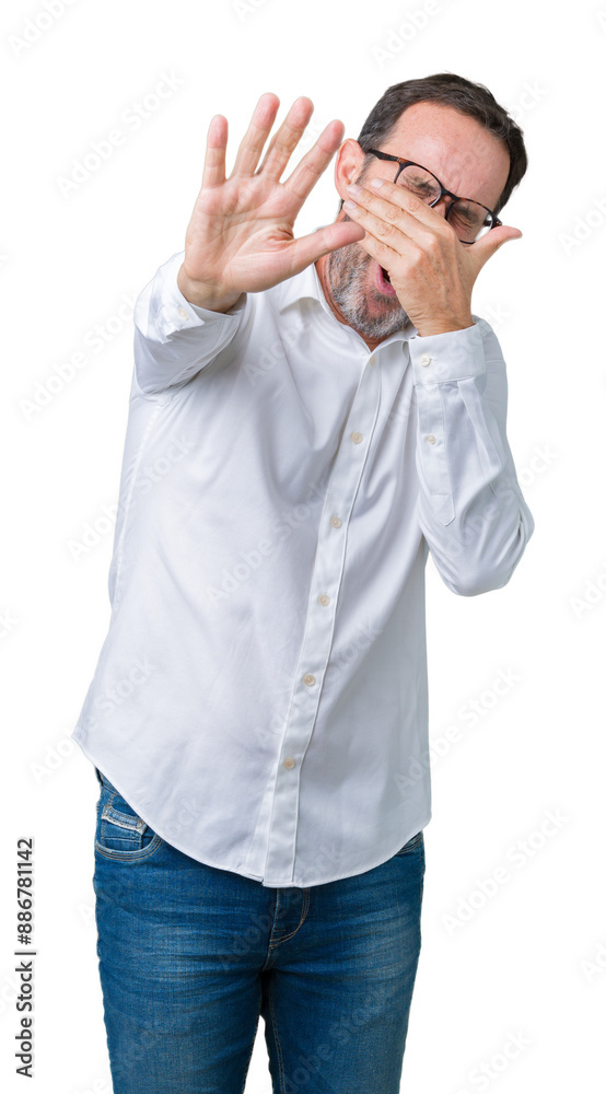 Handsome middle age elegant senior business man wearing glasses over isolated background covering eyes with hands and doing stop gesture with sad and fear expression. Embarrassed and negative concept. Handsome middle age elegant senior business man wearing glasses over isolated background covering eyes with hands and doing stop gesture with sad and fear expression. Embarrassed and negative concept.