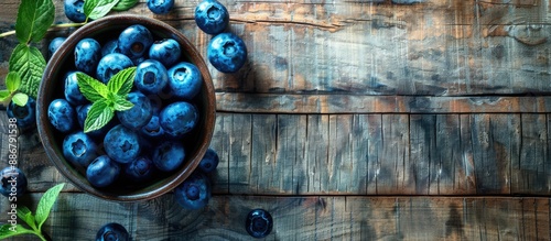 Fresh blueberries resting in a bowl on a rustic wooden table, ideal for a wholesome breakfast dish, with ample copy space image. photo