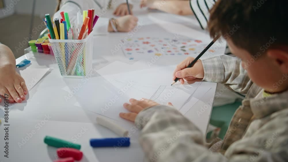 Little artist drawing picture art workshop closeup. Talented kid holding pencil