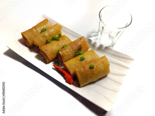 Fried spring rolls filled with vegetables and vermicelli on white plate