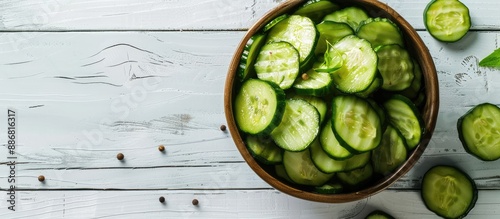 Top view of a delicious display of canned cucumbers in a bowl on a white wooden surface, with ample copy space image. photo