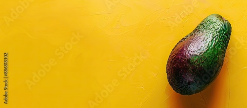 Close-up image of a spoiling avocado on a yellow backdrop, highlighting the concept of unhealthy overripe tropical fruits with room for additional content.