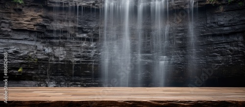 Wooden surface in front of cascading waterfall, with copy space image.