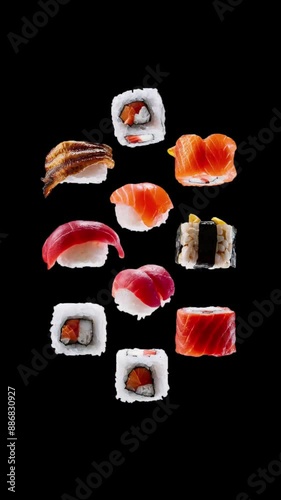 Pieces of rolls and sushi with salmon, eel and tuna fly up into the air, hover and quickly fall down. Vertical realistic animation of Asian food on a black background