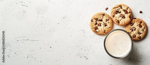 A delicious snack of cookies and milk presented on a rustic white background in a clear glass, ideal for showcasing with copy space image in a flat lay. photo