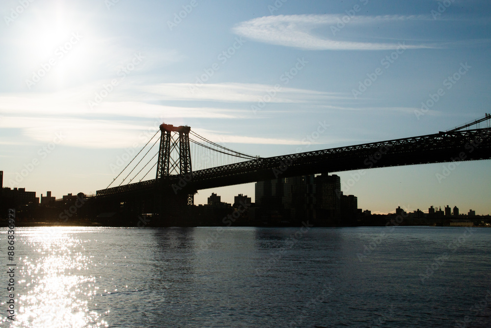 Fototapeta premium Silueta del puente Williamsburg al amanecer desde la orilla de Manhattan en Nueva York, USA. Vistas desde el parque John V. Lindsay East River. 09 de Noviembre de 2019.