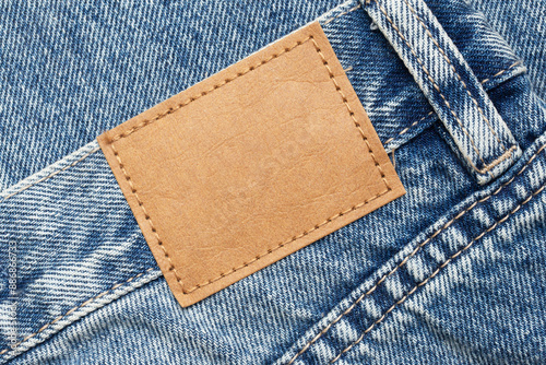 Wallpaper Mural Fashion background with empty copy space for graphic design. Blank leather label tag. Blue jeans denim texture with thread sew lines. Brown clothing tag. Torontodigital.ca