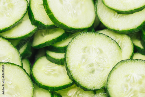Cucumber slices pattern. Pile of round cucumber cuts texture. Green vegetable background. Cucumber cross section. Polish mizeria salad ingredients. photo