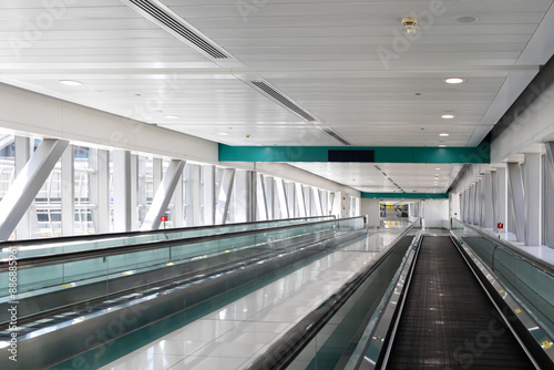 Fototapeta Naklejka Na Ścianę i Meble -  A long modern transit hallway with a green and white ceiling and a green stripe on the ceiling