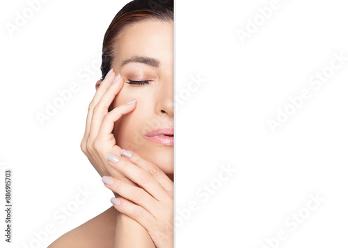 Beautiful middle-aged woman with glowing skin touching her face. Skincare and beauty concept with copy space. © Casther